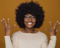 young african american woman with glasses and afro hair making a gesture with her hands