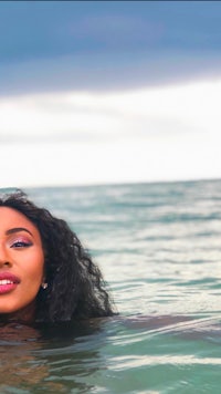 a woman is floating in the ocean with her face in the water